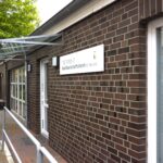 Außenaufnahme des Nachbarschaftsheims St. Pauli. Zu erkennen das Schild "Treffpunkt Nachbarschaftsheim St. Pauli e.V." und eine Angebotstafel "Mo-Fr ab 14 Uhr"