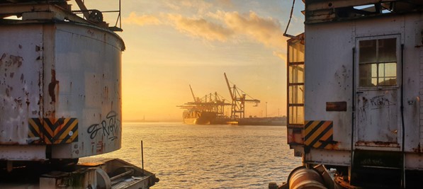 Ausblick von der Deutschen Seemannsmission Altona e.V. über den Hafen zwischen zwei alten Hafenkränen hindurch. im Hintergrund Containerbrücken