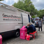Das Gesundheitsmobil in Hamburg auf der Reeperbahn. Vor dem Mobil warten zwei Patienten